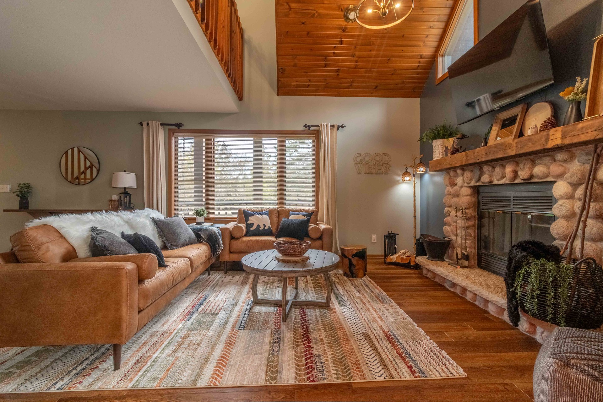 Cozy cabin living room with stone fireplace and leather sofas